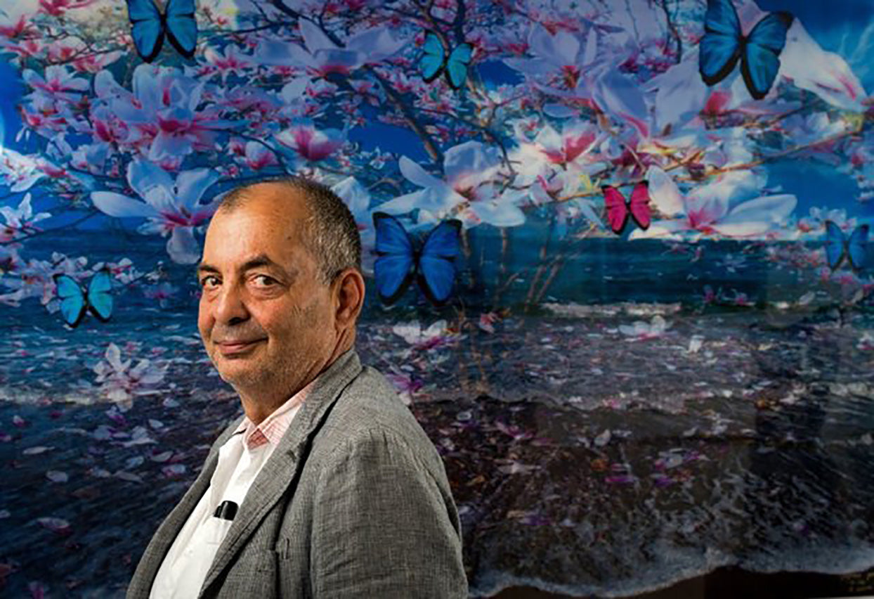 photo of Isack Kousynsky standing infront of one of his paintings