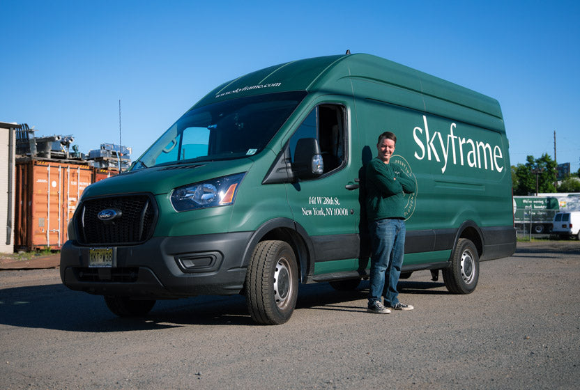 skyframe employee standing infront of the green sky frame delivery and install van