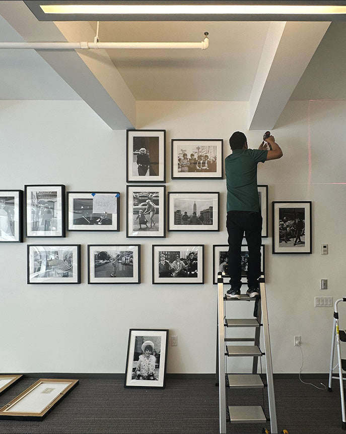 Skyframe installer hanging a gallery wall — white-glove art installation service NYC & Miami