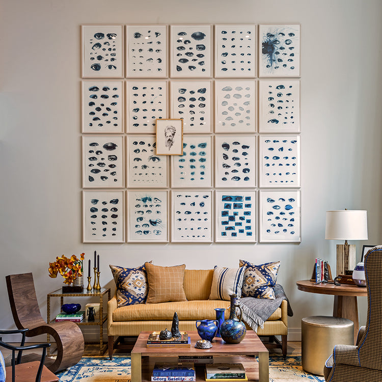 Wall designed by scott sanders including blue abstract pieces in bright gold frames