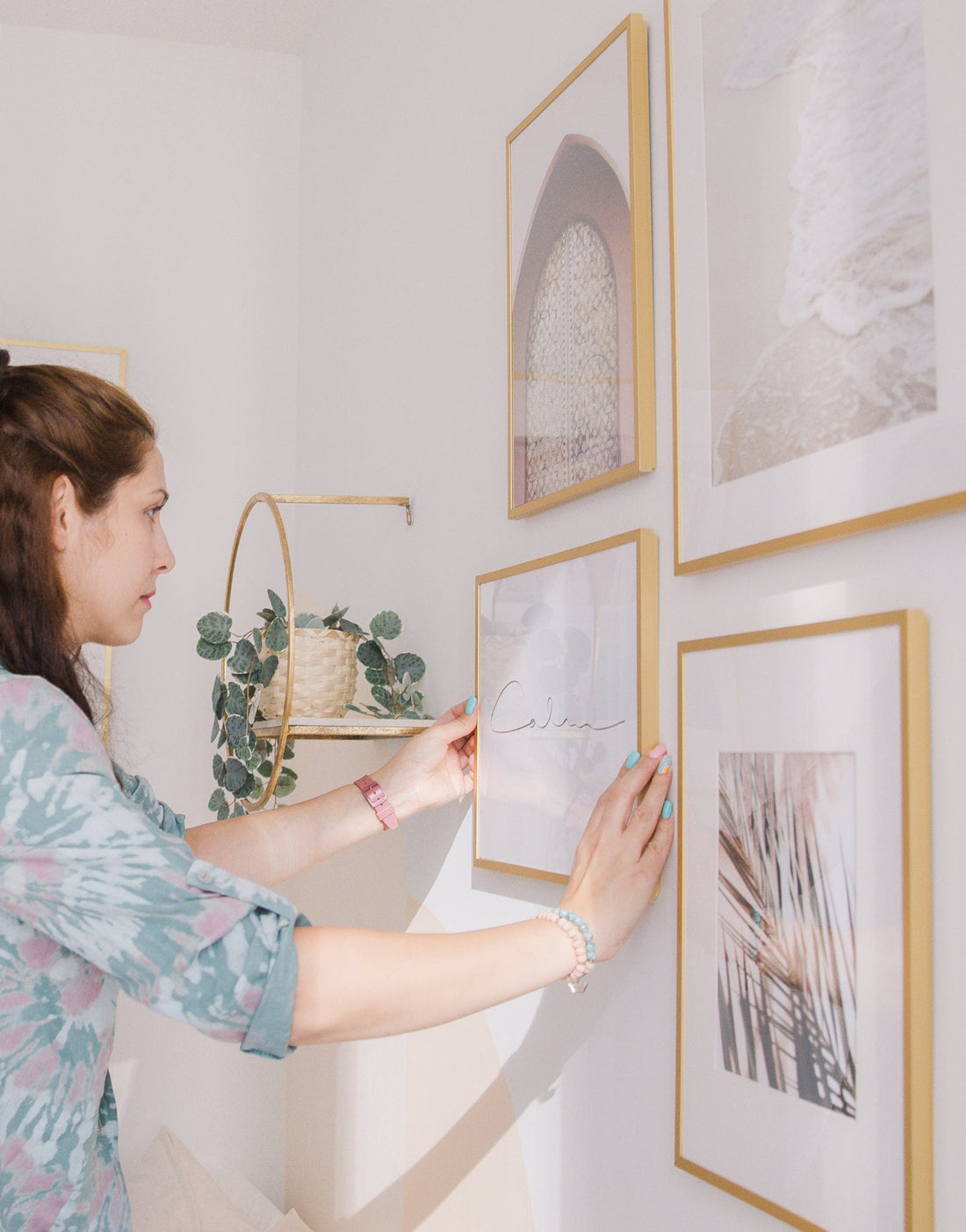Interior designer hanging curated framed artwork sourced and printed by Skyframe
