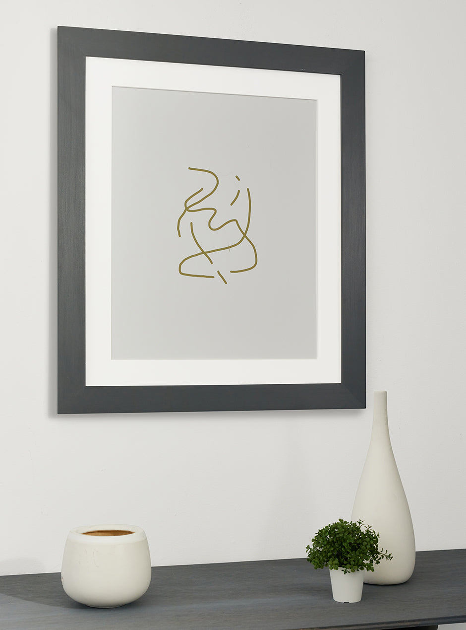 grey frame holding abstract art hung above table with various objects