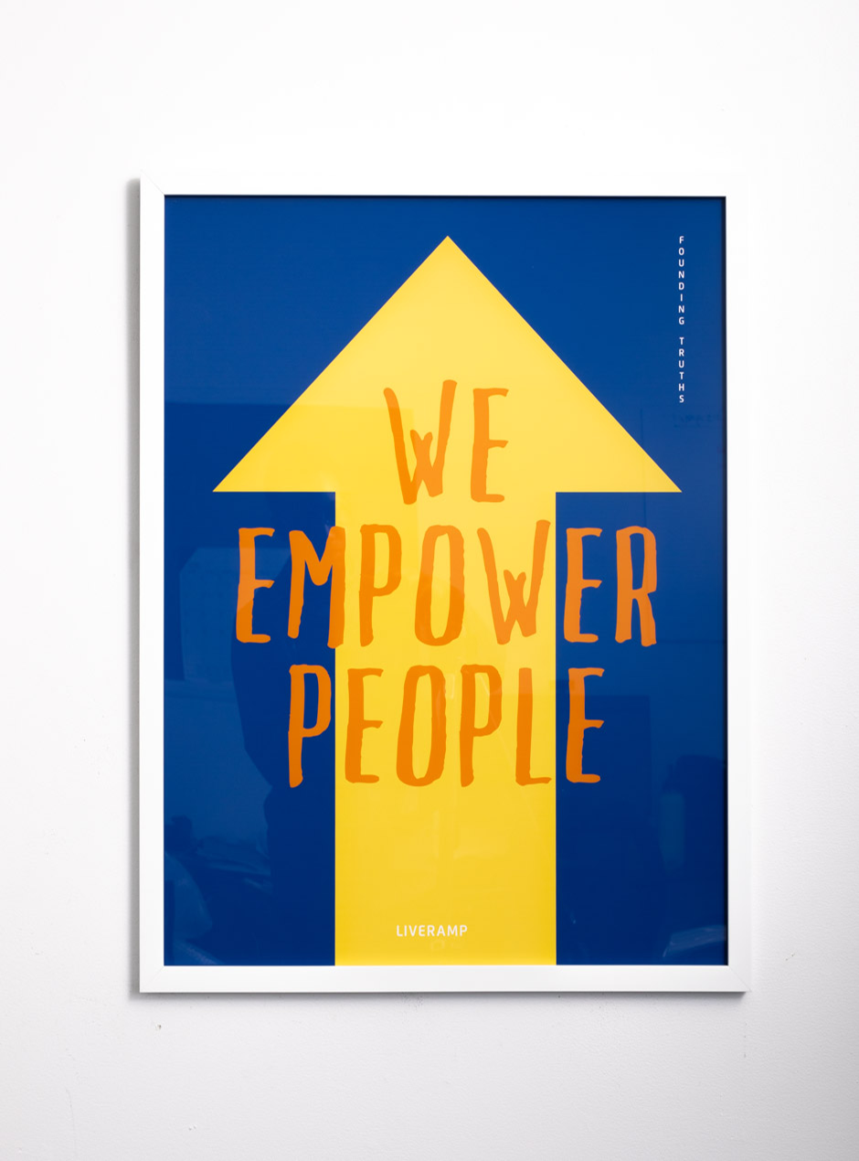 we empower people on blue background with yellow arrow in thin white frame
