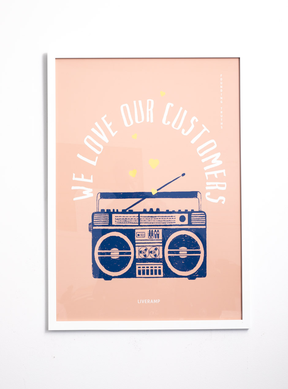 We Love Our Customers on pink background with navy stereo in thin white frame 