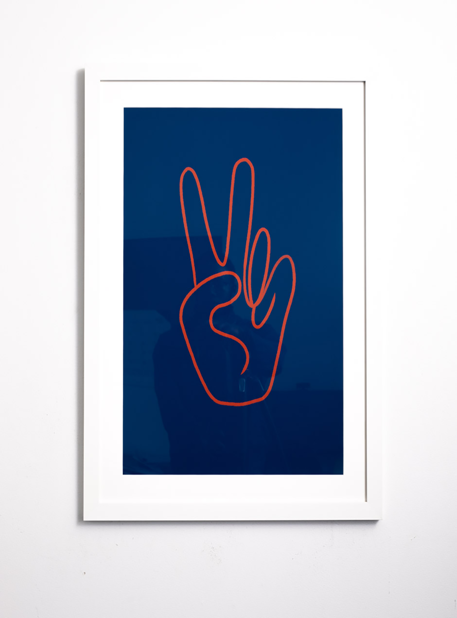 orange peace sign against blue background in white frame 