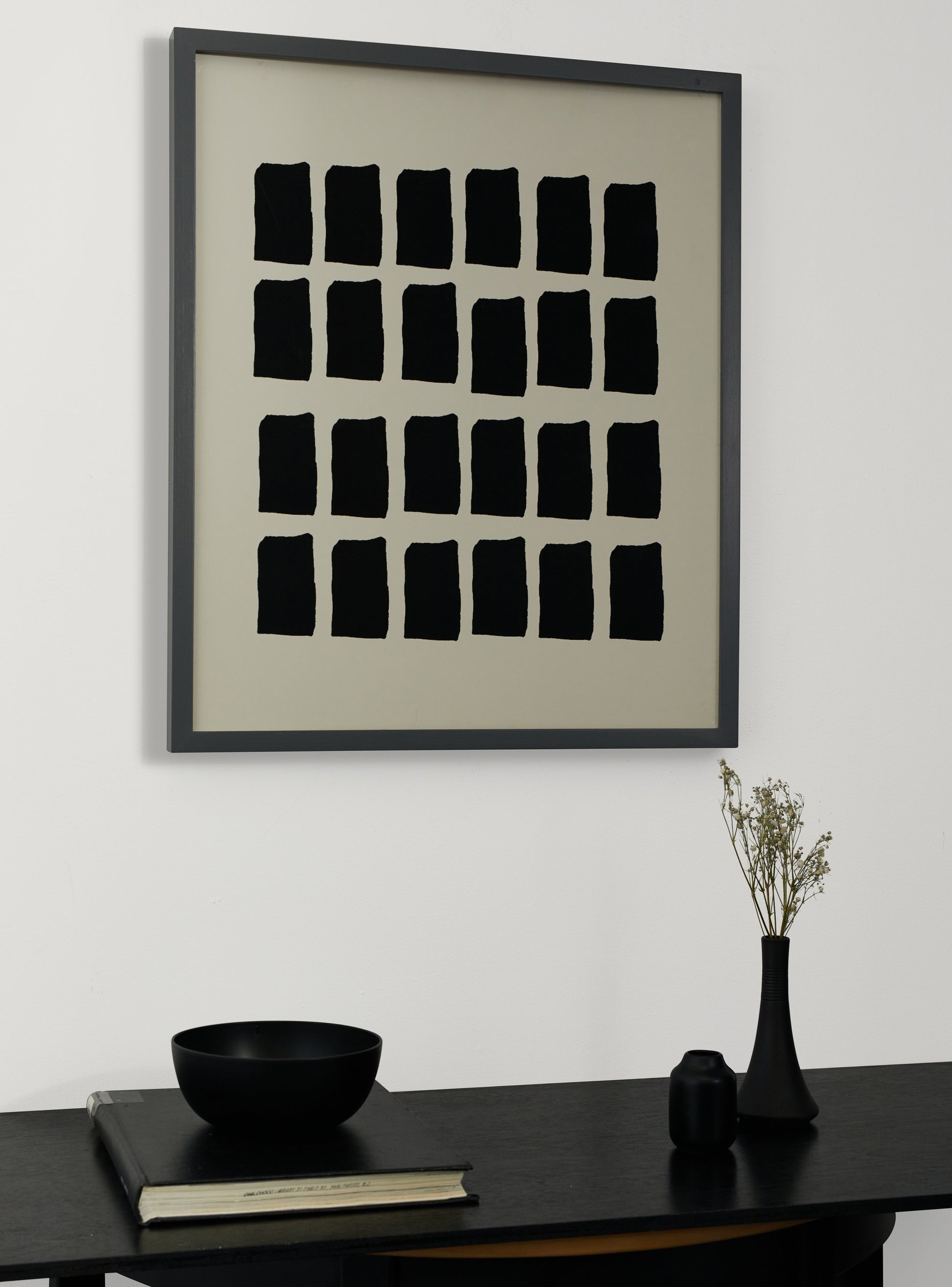 Photograph of a frame in a home with a table underneath showing various items