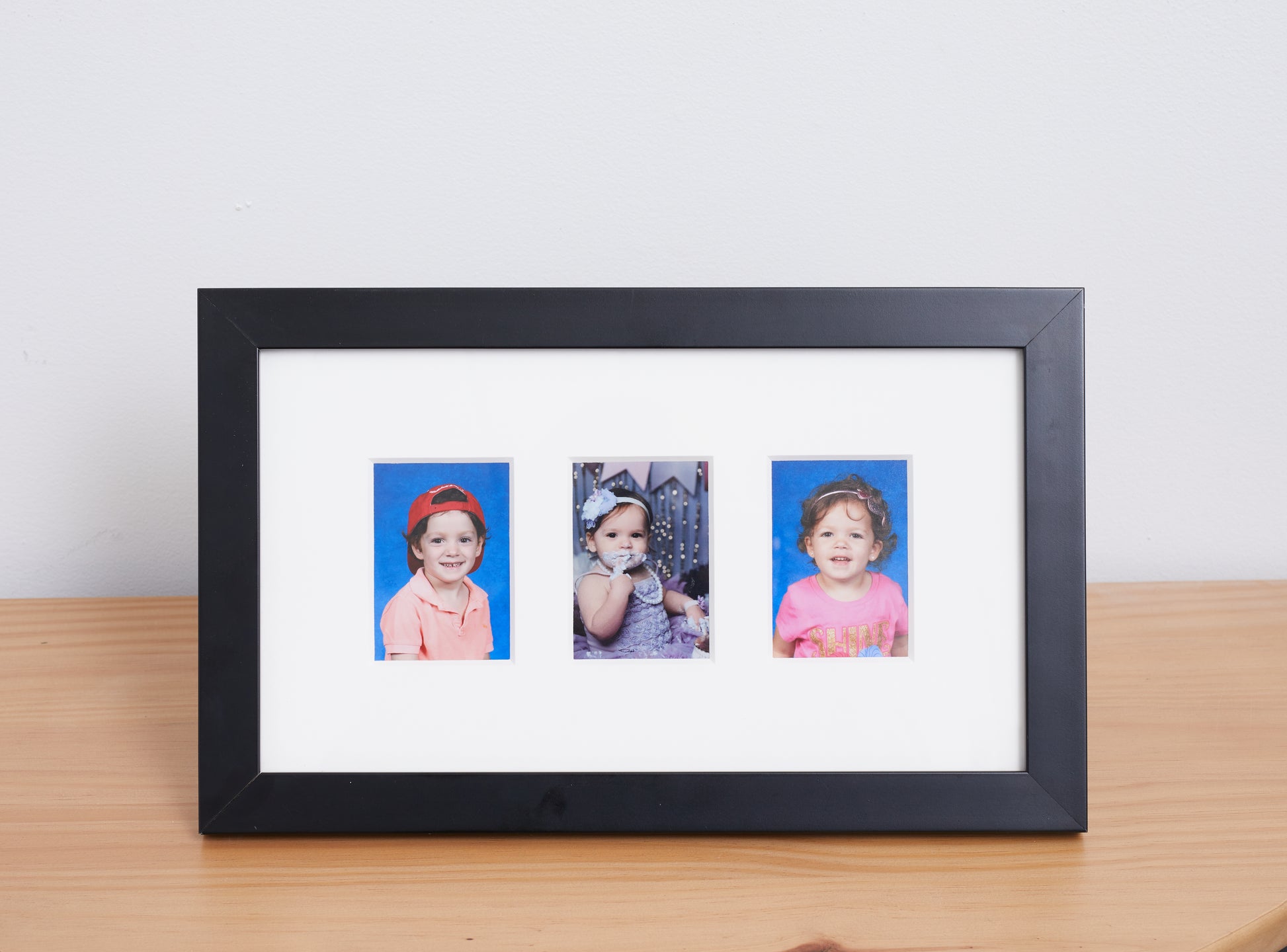 family photos in a 3 window black picture frame