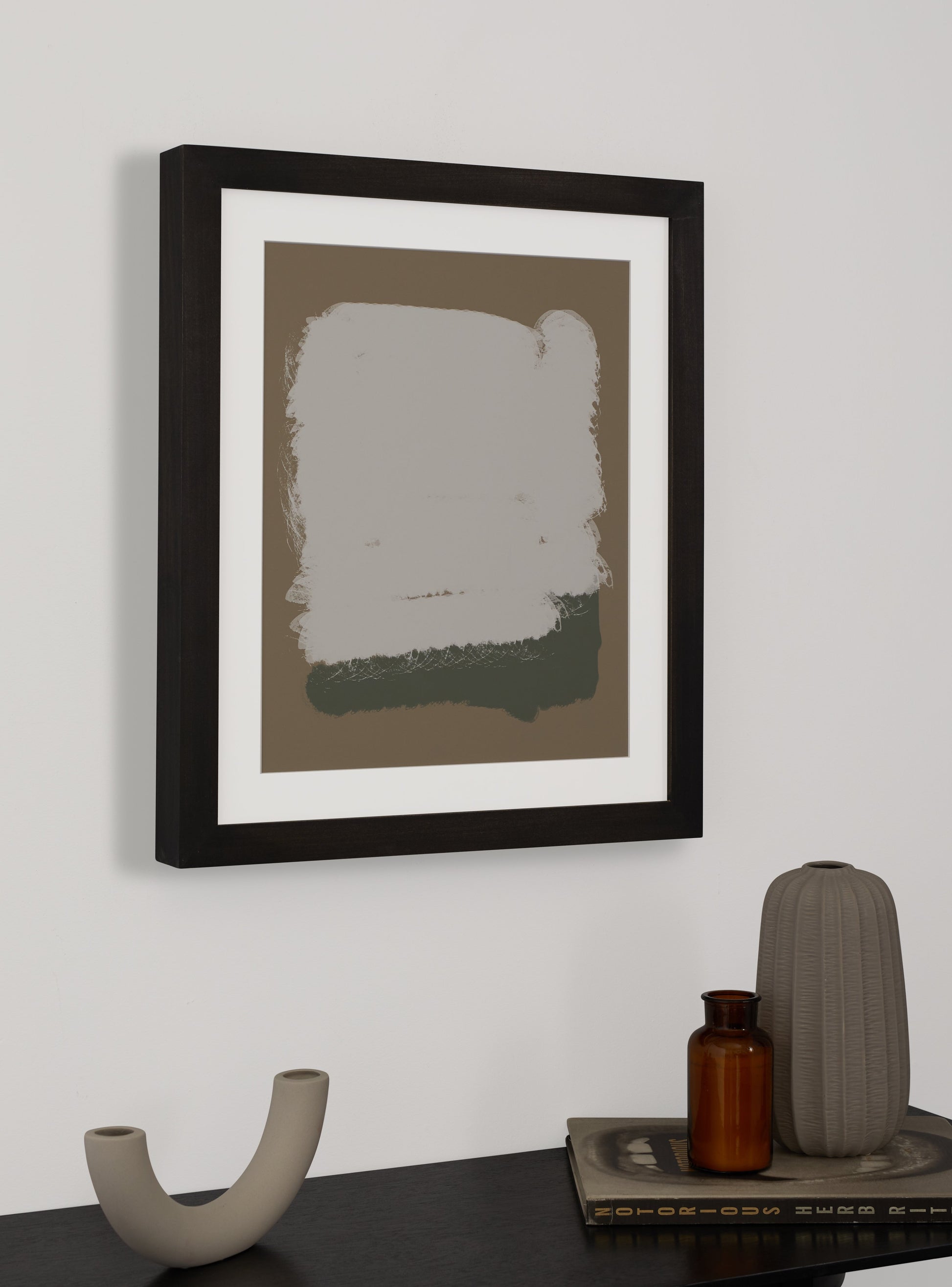 Photograph of a frame in a home with a table underneath showing various items