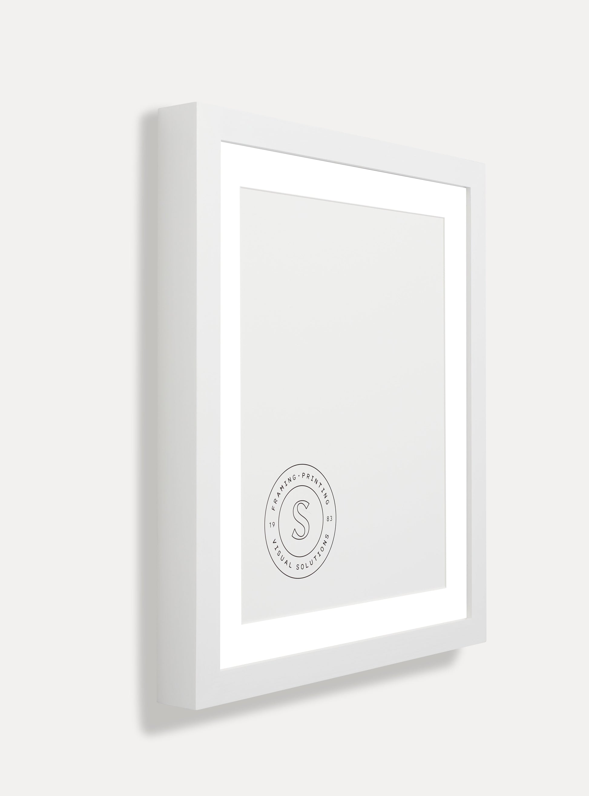 Side photo of a wooden picture frame on an off-white wall 