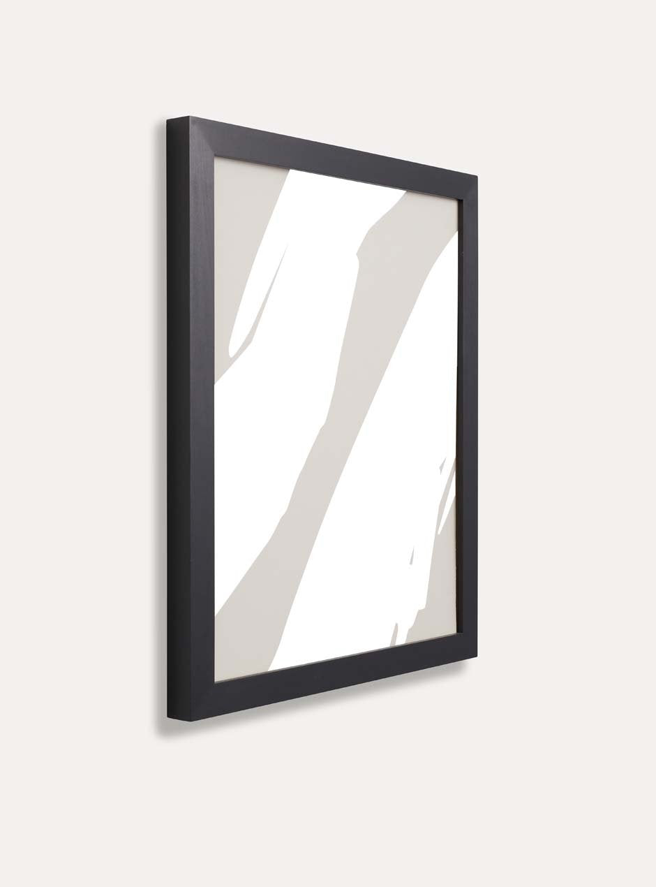 side profile of black solid poplar frame with neutral blotchy modern artwork against white wall