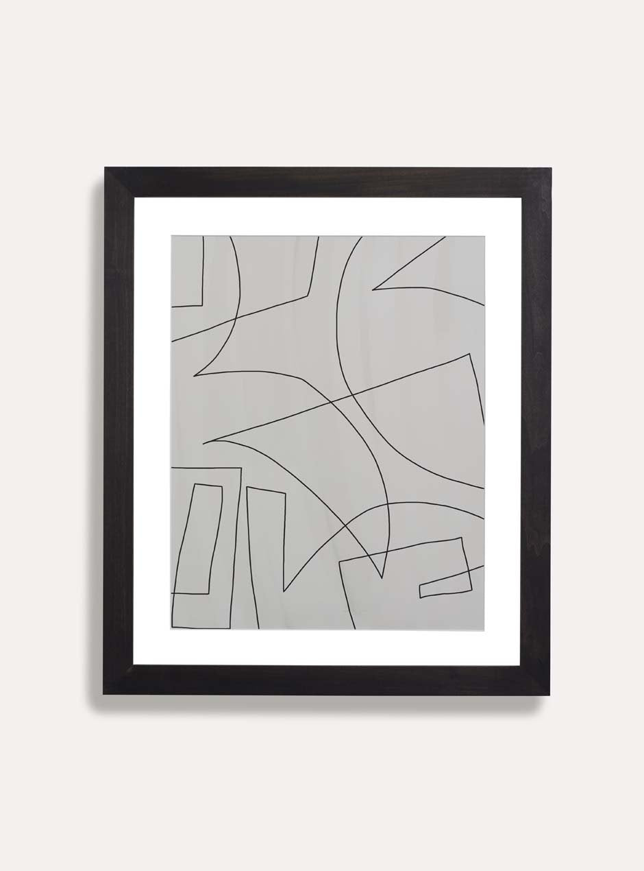 black and white abstract print in black frame on white wall