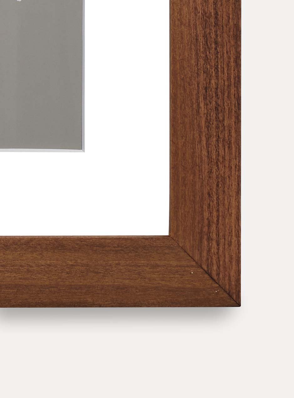 Close up of corner of brown wooden frame holding abstract art