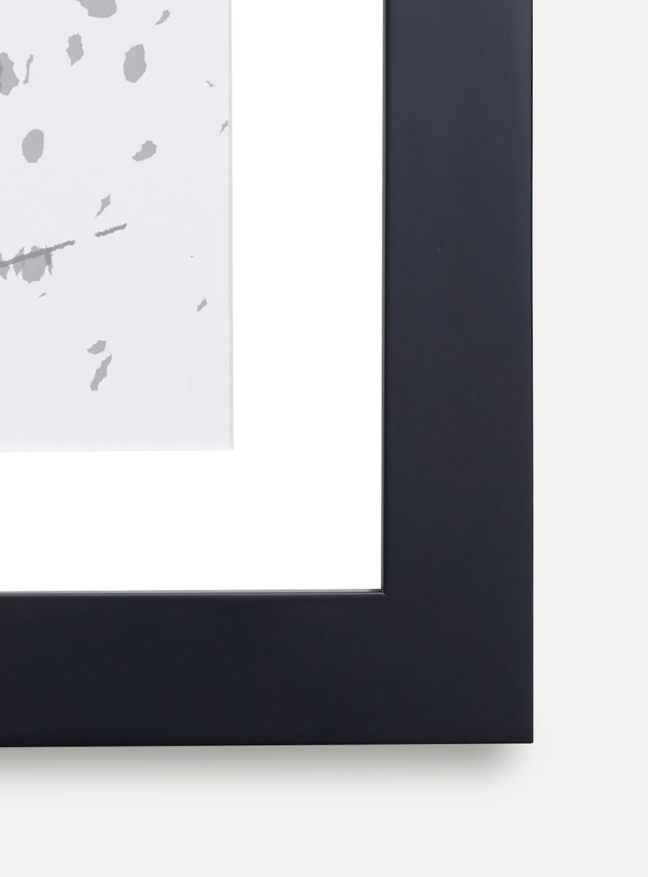 Close up of corner of black frame holding abstract art