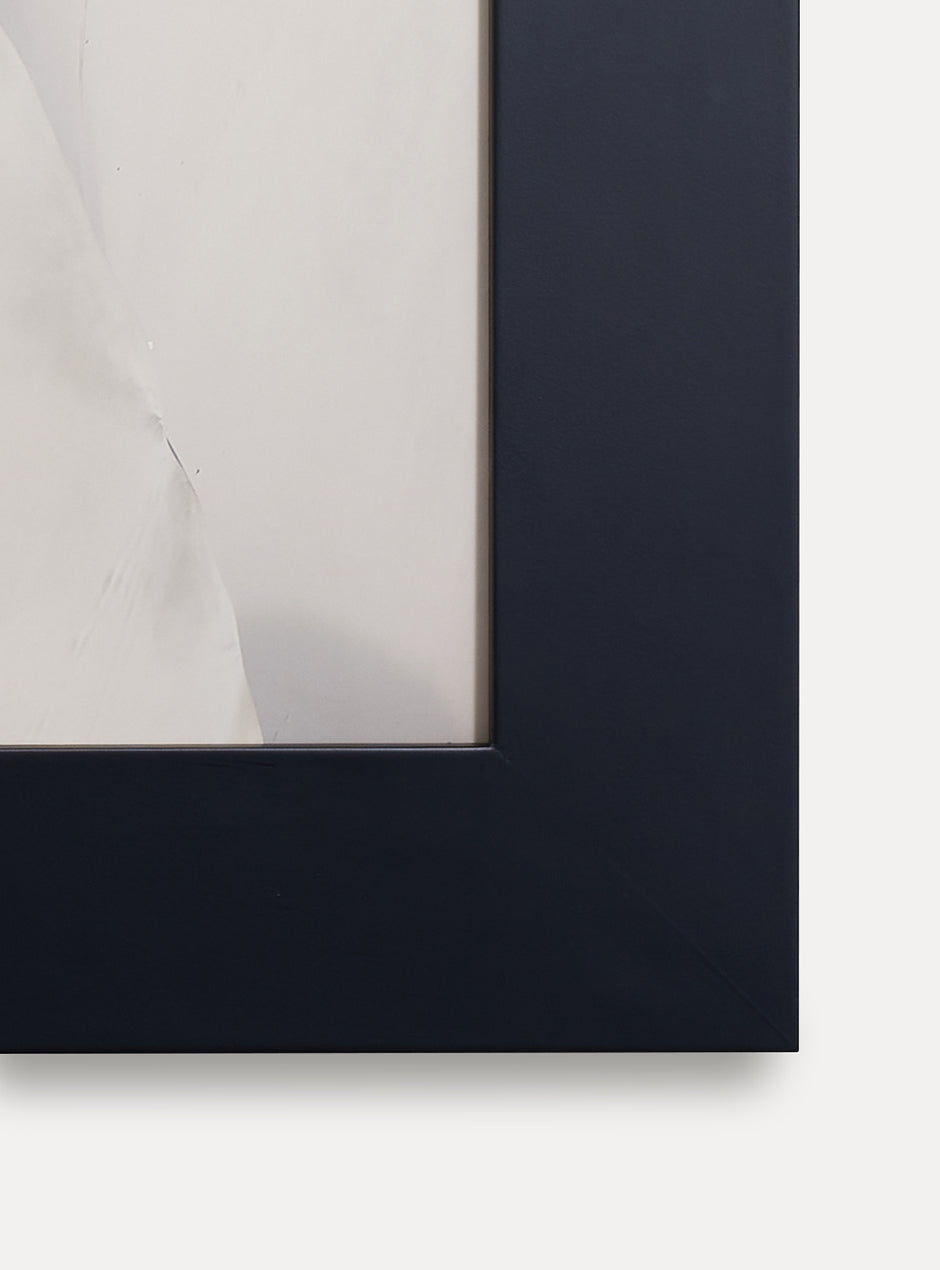 Close up of corner of black frame holding abstract art