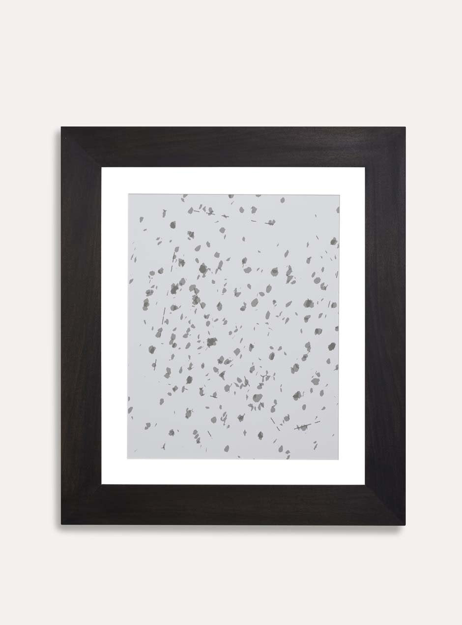 gray and white abstract print in black frame on white wall