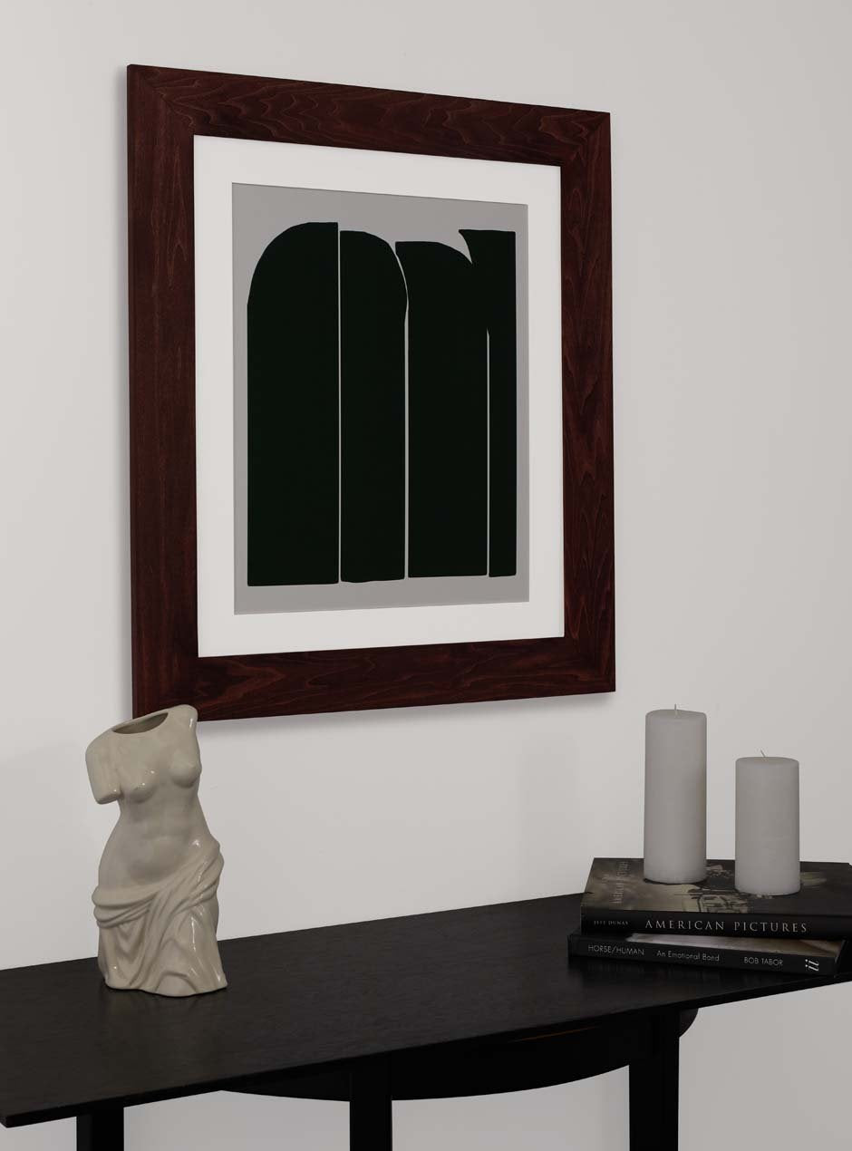 dark stained wooden frame holding abstract painting  hung above table with various small objects