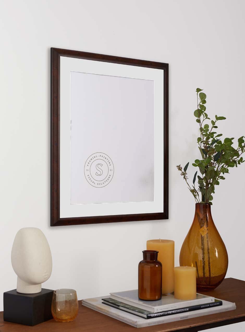 dark wooden frame hung above table with miscellaneous objects