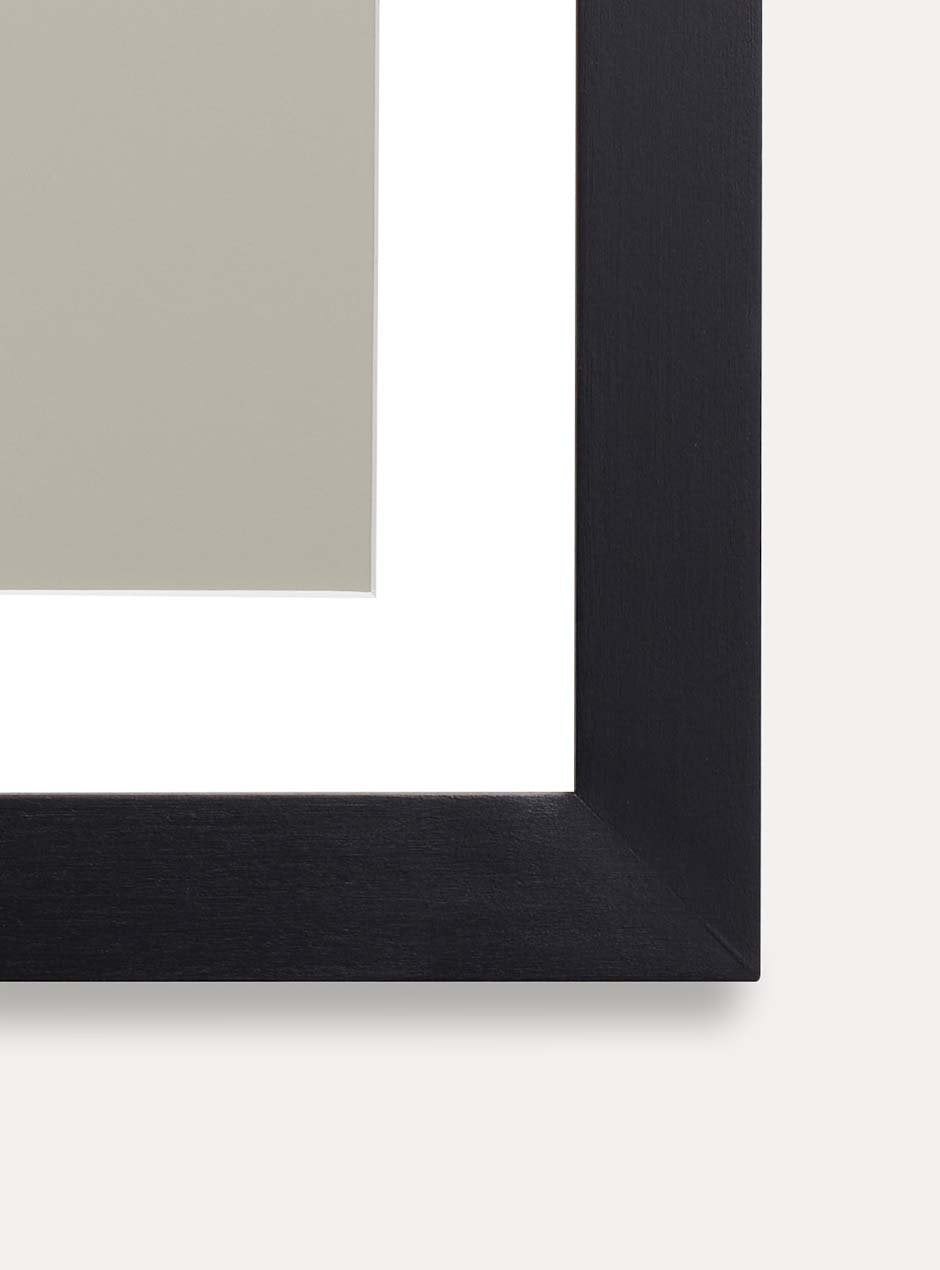 detail photo showing wood grain of black solid poplar frame with neutral blotchy modern artwork against white wall