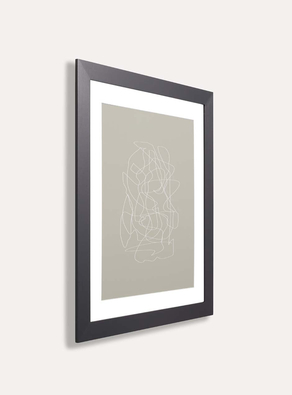 side profile of black solid poplar frame with neutral blotchy modern artwork against white wall