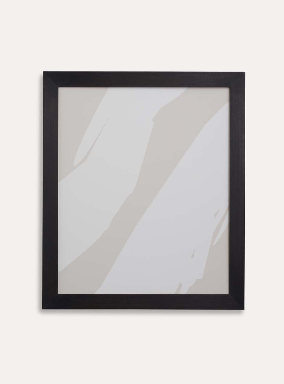 tan and white abstract print in black frame on white wall