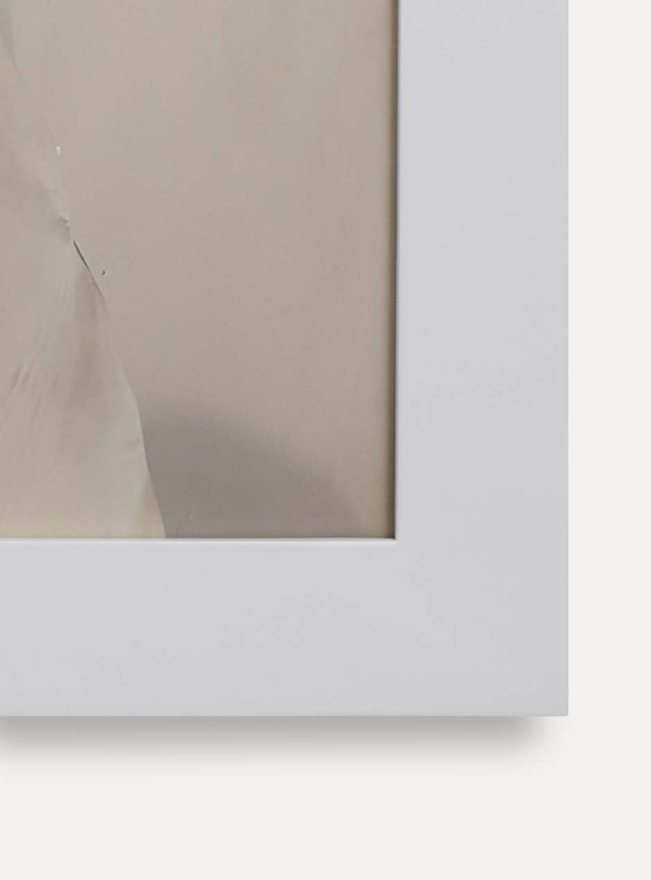 Close up of corner of white frame holding abstract art