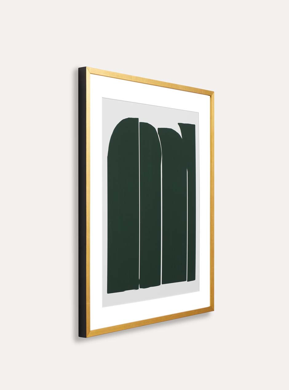 side profile of shiny yellow gold leafed high end frame with white mat border and green artwork resembling stones.