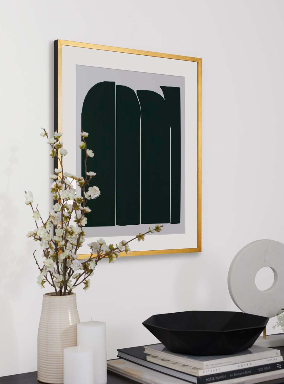 shiny yellow gold leafed high end frame with white mat border and green artwork resembling stones over a black entryway table with flowers and modern decor