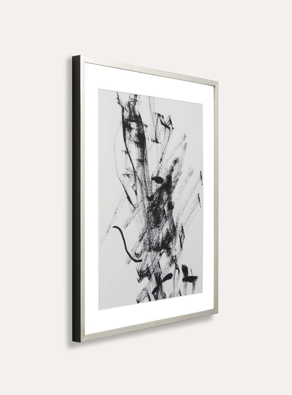 side profile showing black side of reflective metallic silver thin frame with various lines across moulding shown with white mat and an abstract ink line art piece