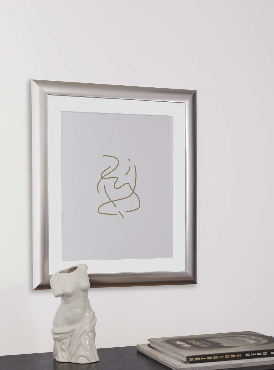 silver frame holding abstract art hung above table with various objects
