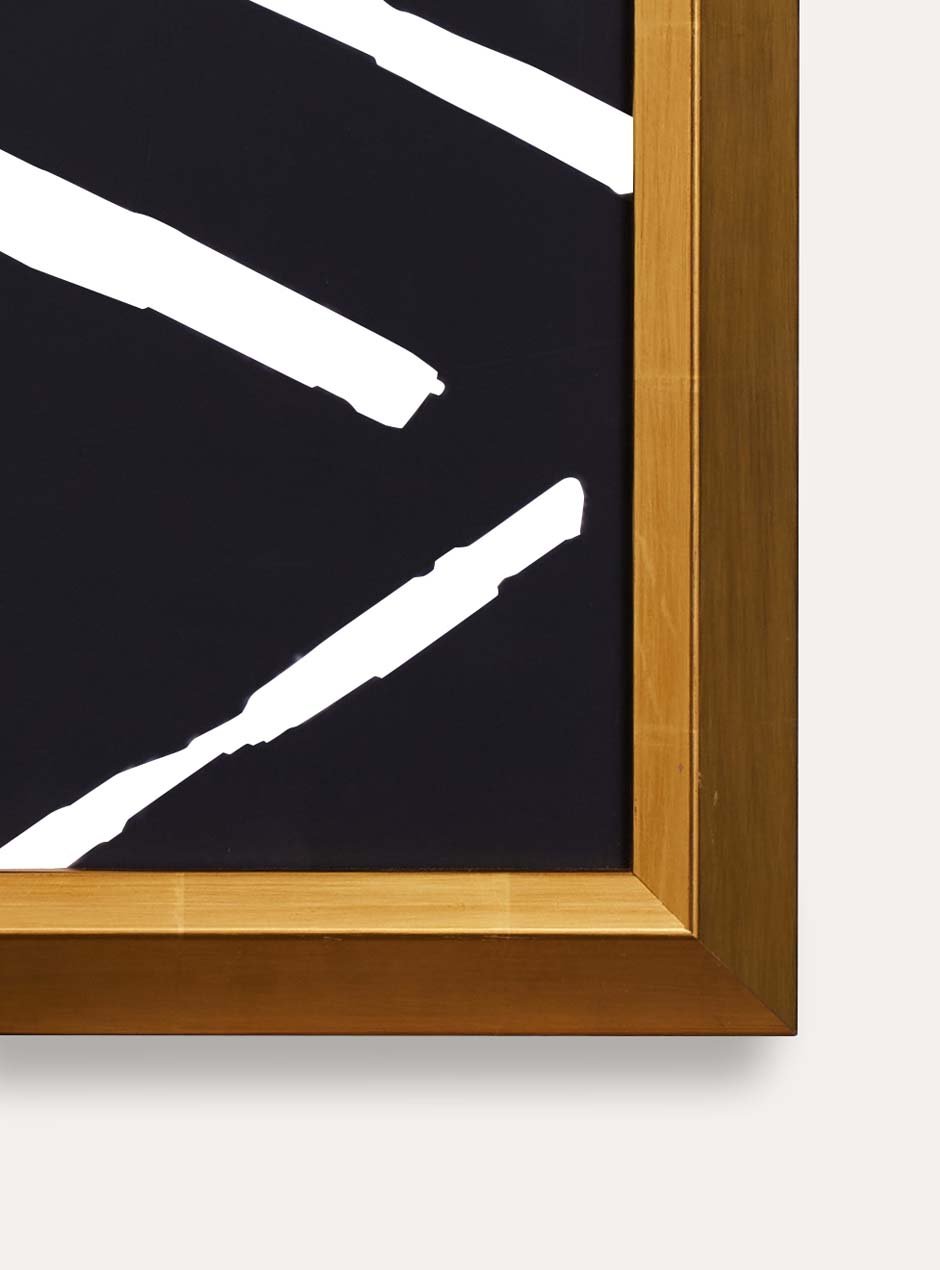 detail photo showing bright yellow gold leafed frame with bevel towards the center artwork which is dark black with white criss cross pattern modern art on white wall