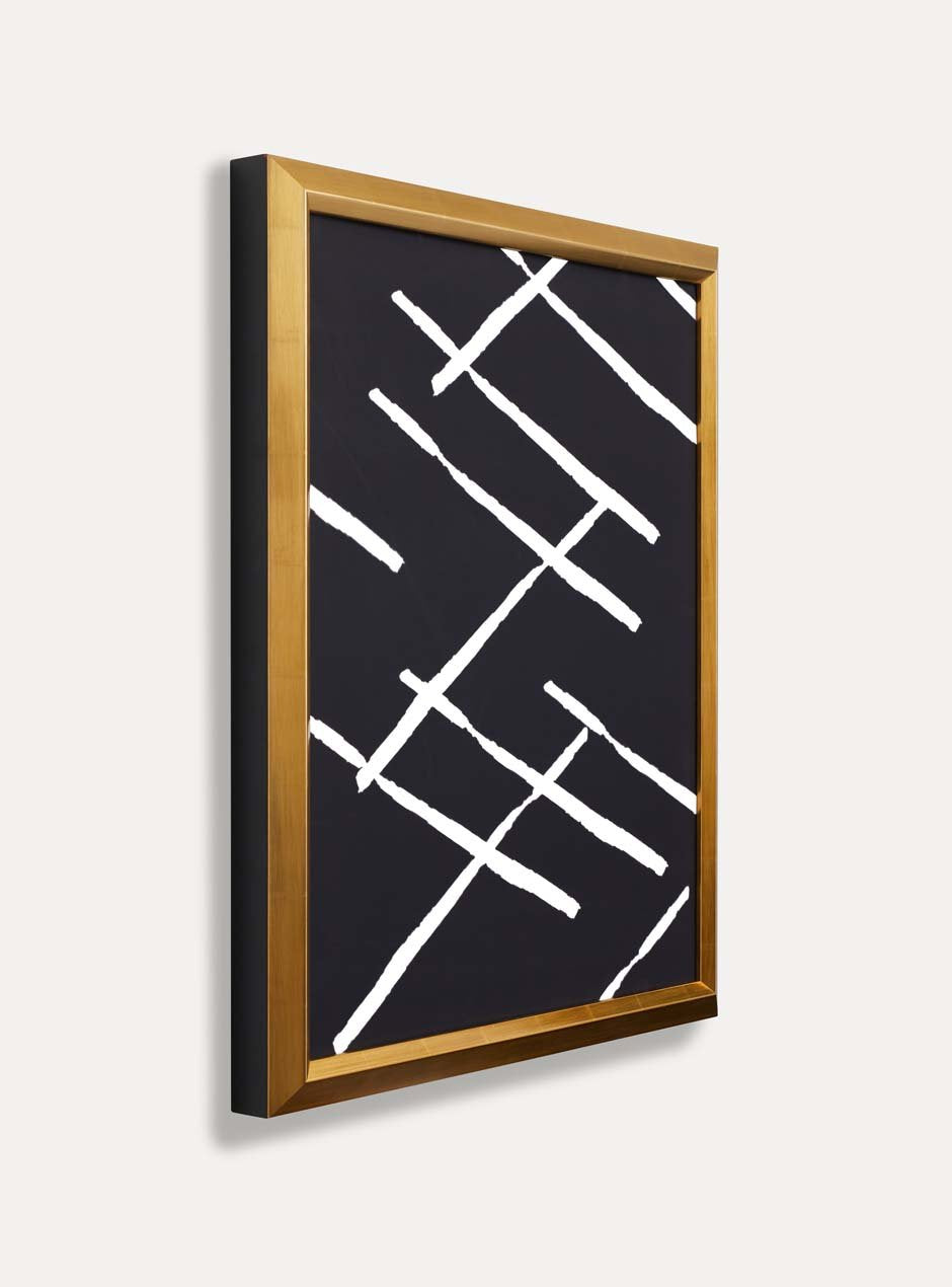 side profile showing depth bright yellow gold leafed frame with bevel towards the center artwork which is dark black with white criss cross pattern modern art on white wall