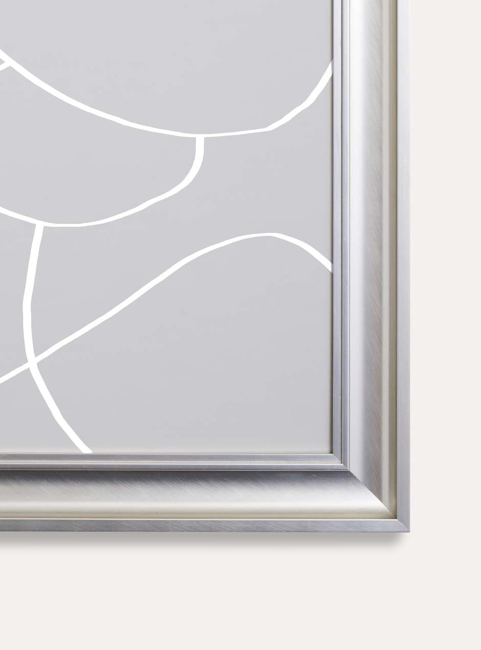 detailed photo showing joined corner of silver metallic shiny picture frame with depth and higher ridges showing circular modern abstract grey art against white wall