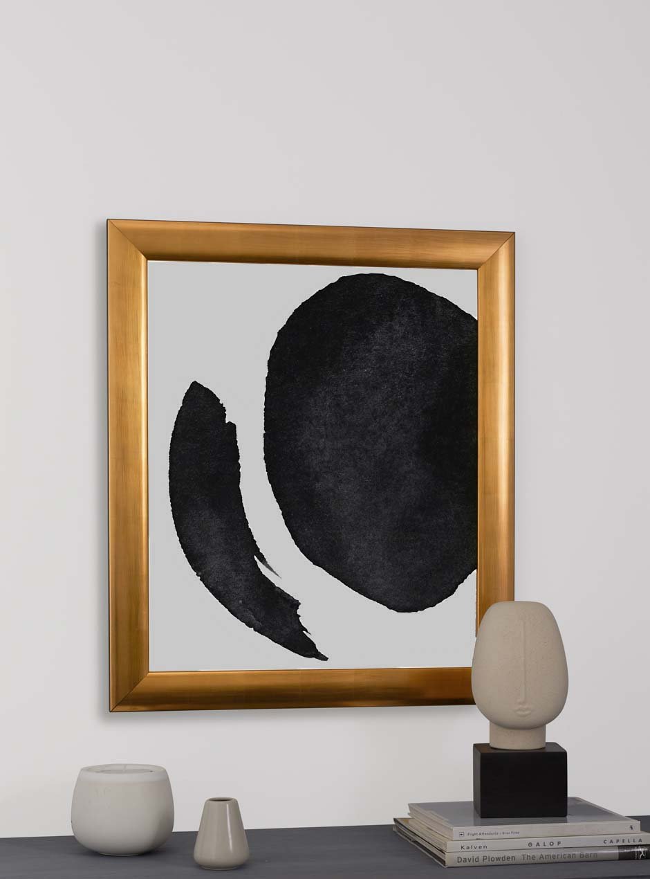 gold frame holding abstract art hung above table with various objects