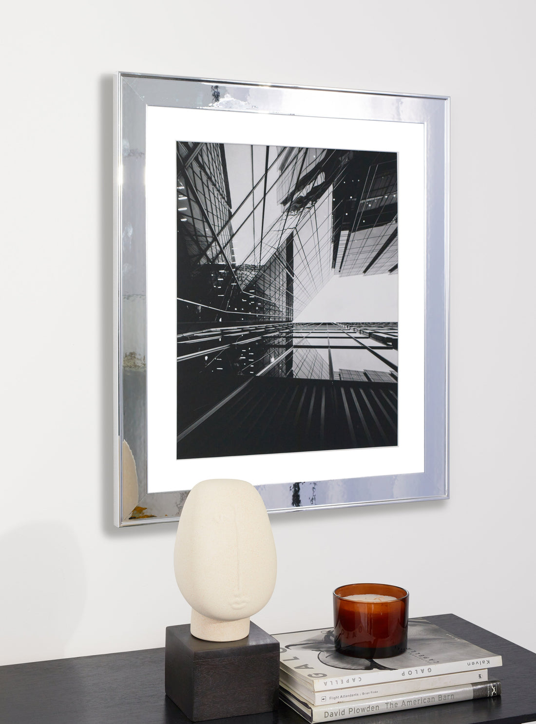 Photograph of a frame in a home with a table underneath showing various items