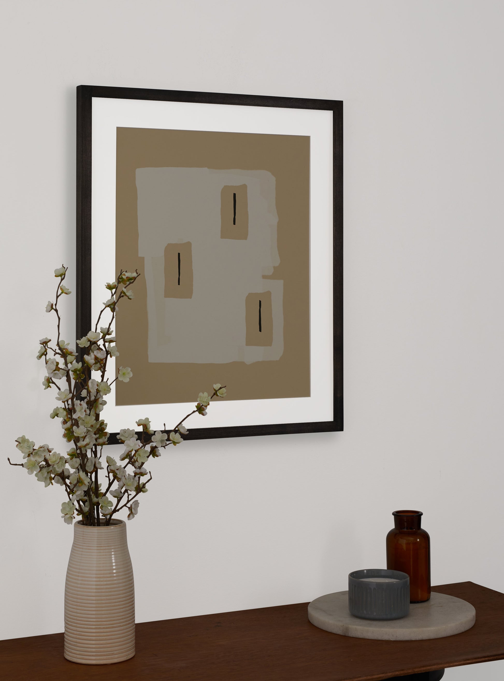 Photograph of a frame in a home with a table underneath showing various items