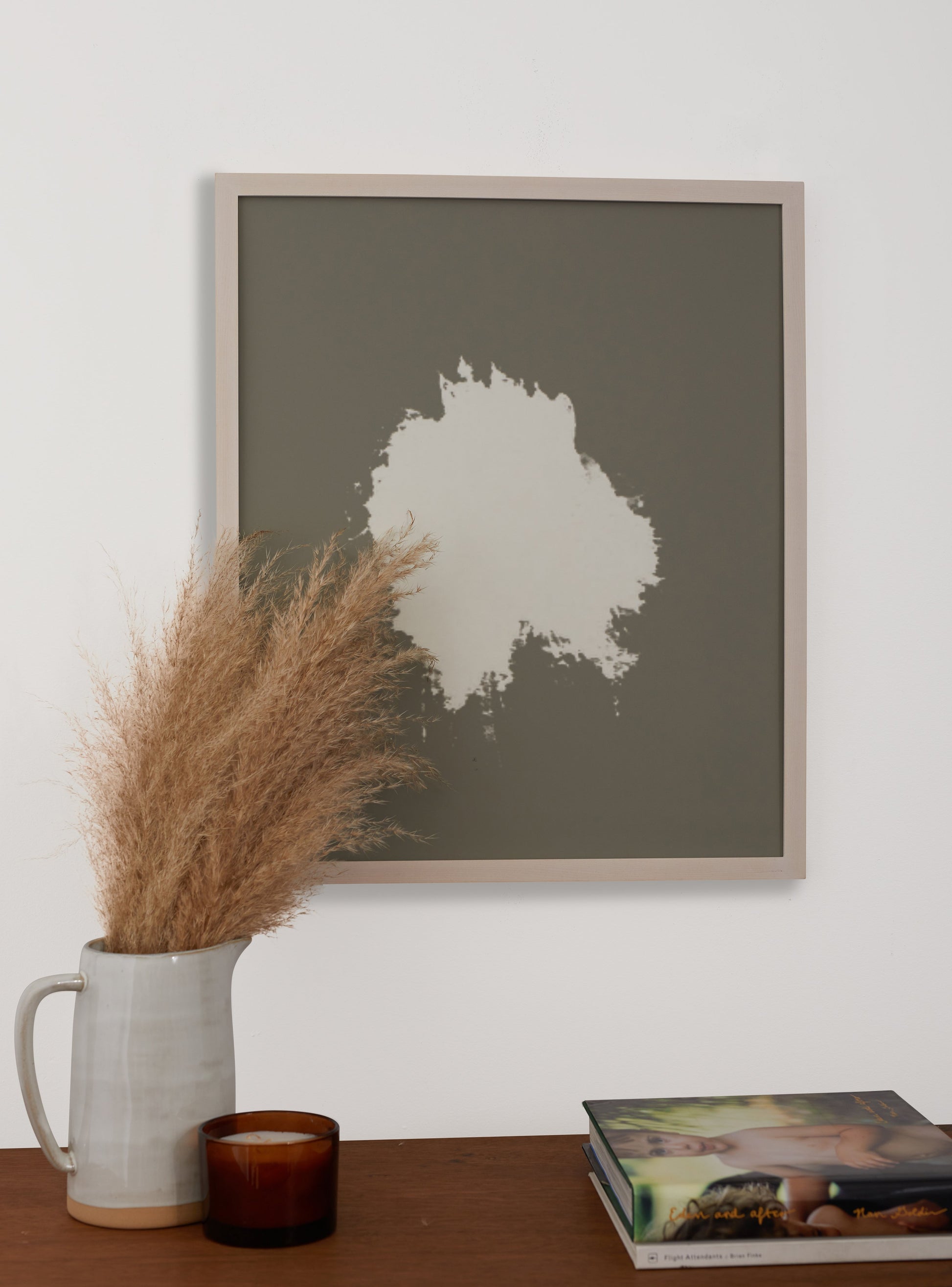 Photograph of a frame in a home with a table underneath showing various items