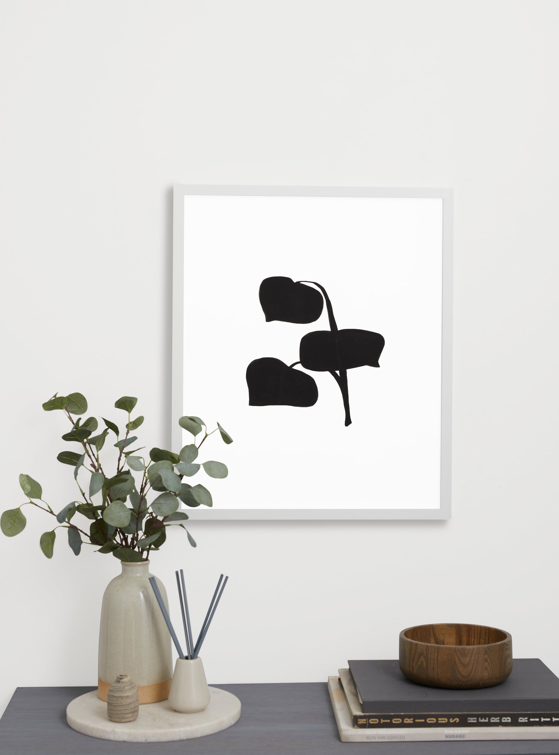 Photograph of a frame in a home with a table underneath showing various items