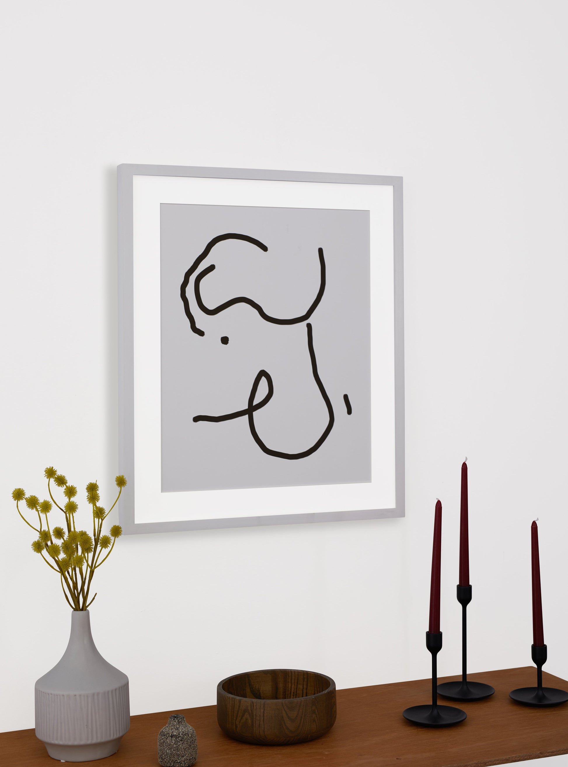 Photograph of a frame in a home with a table underneath showing various items