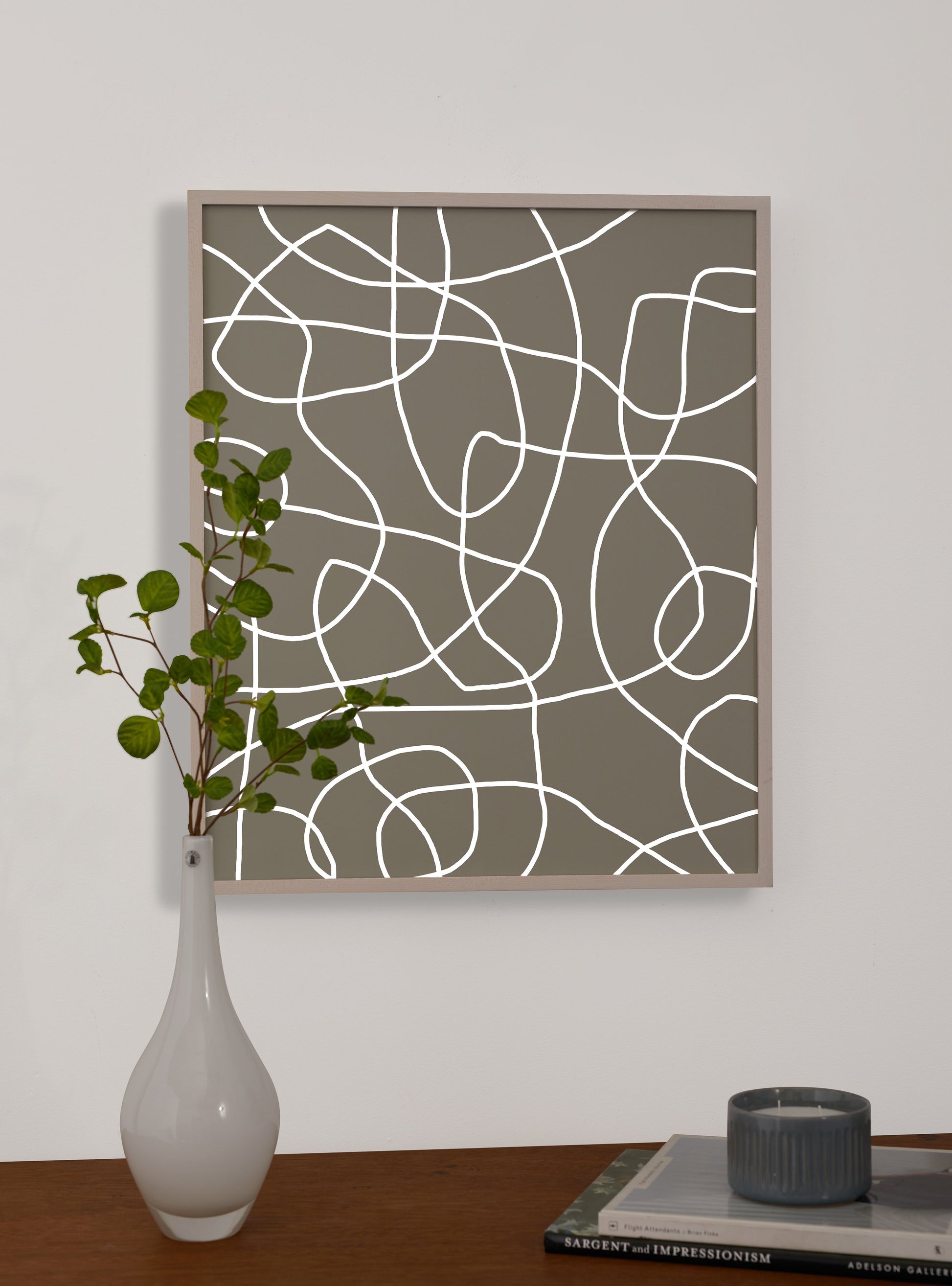 Photograph of a frame in a home with a table underneath showing various items