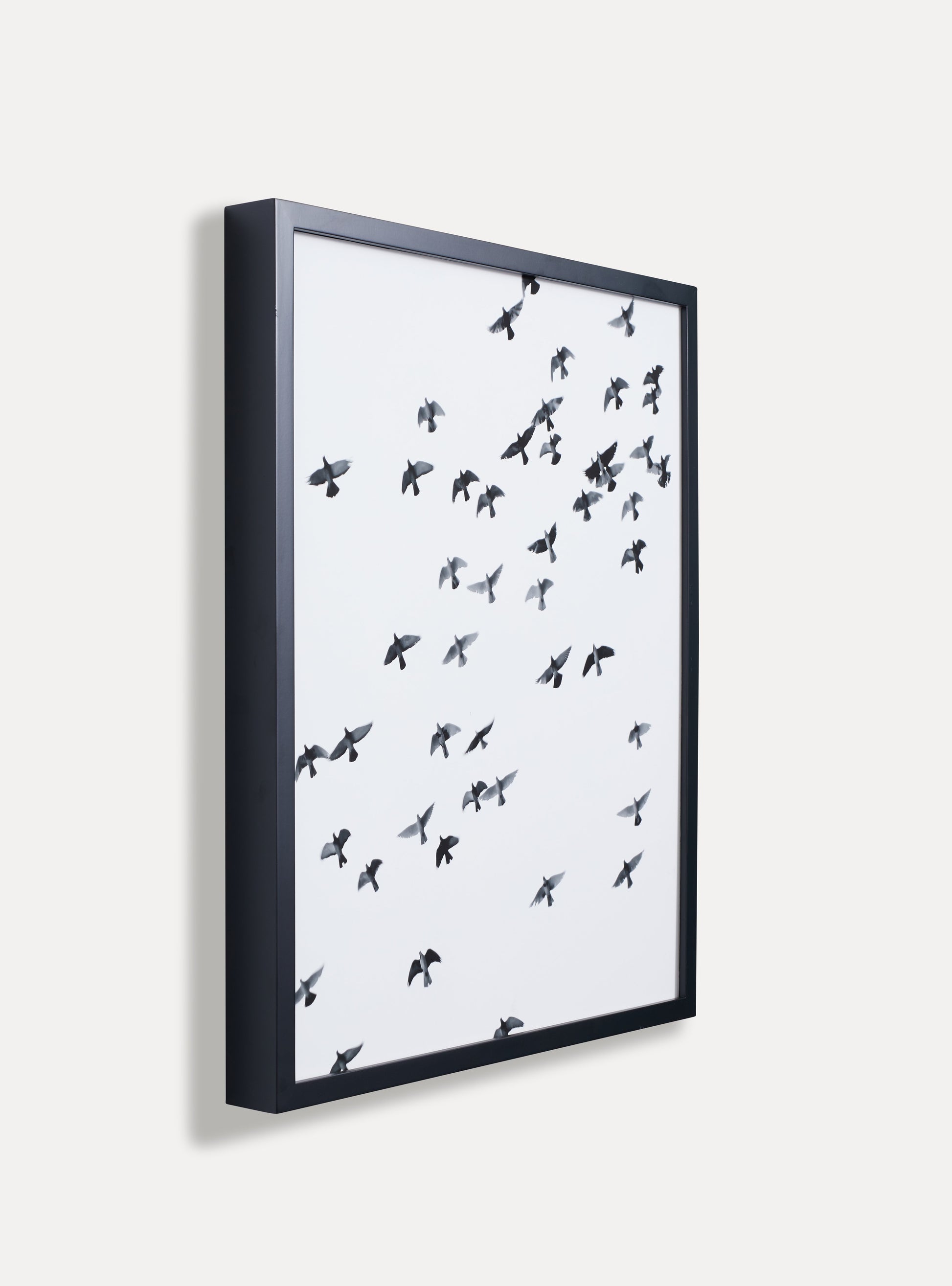 Side photo of a wooden picture frame on an off-white wall