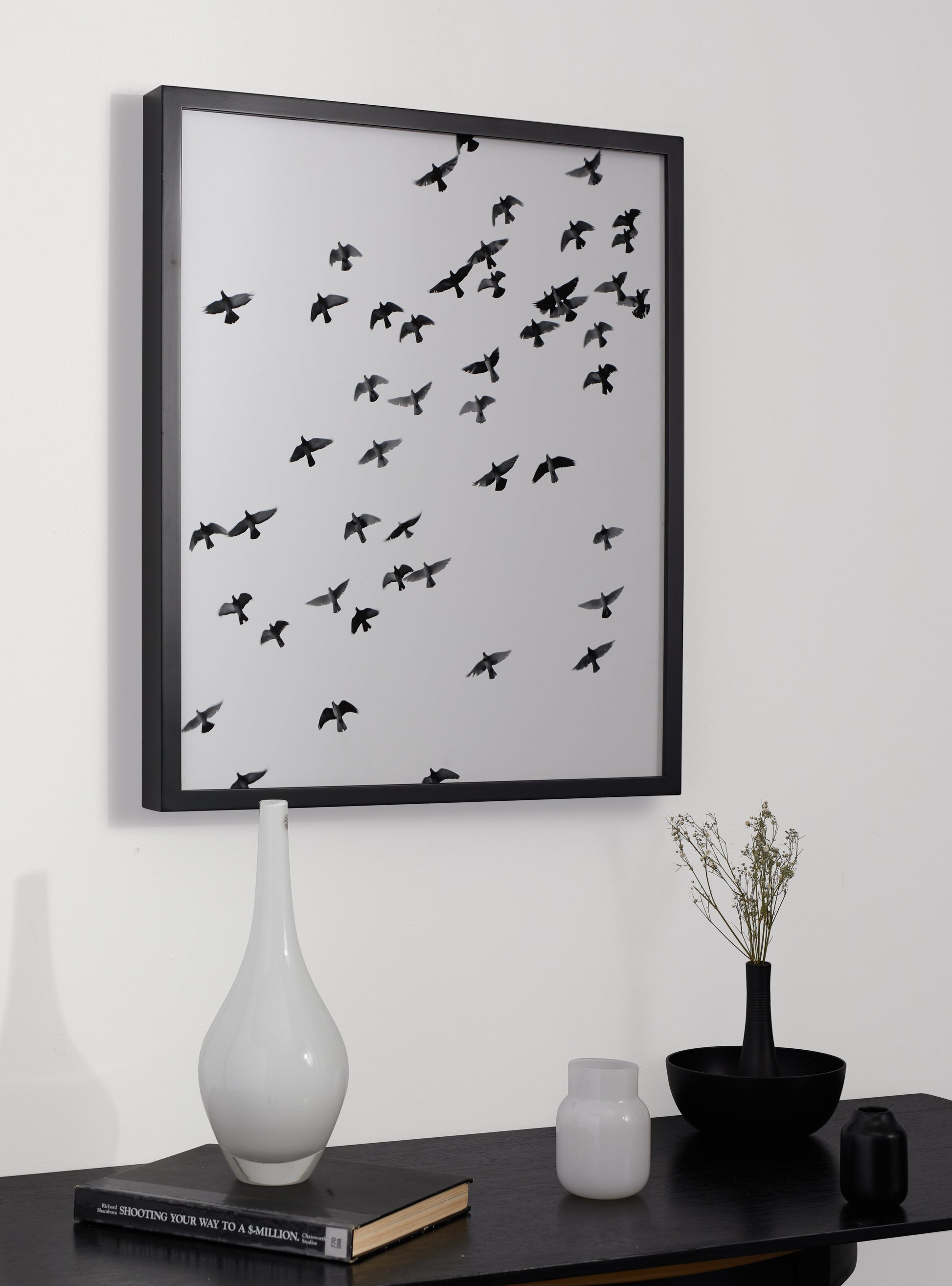 Photograph of a frame in a home with a table underneath showing various items