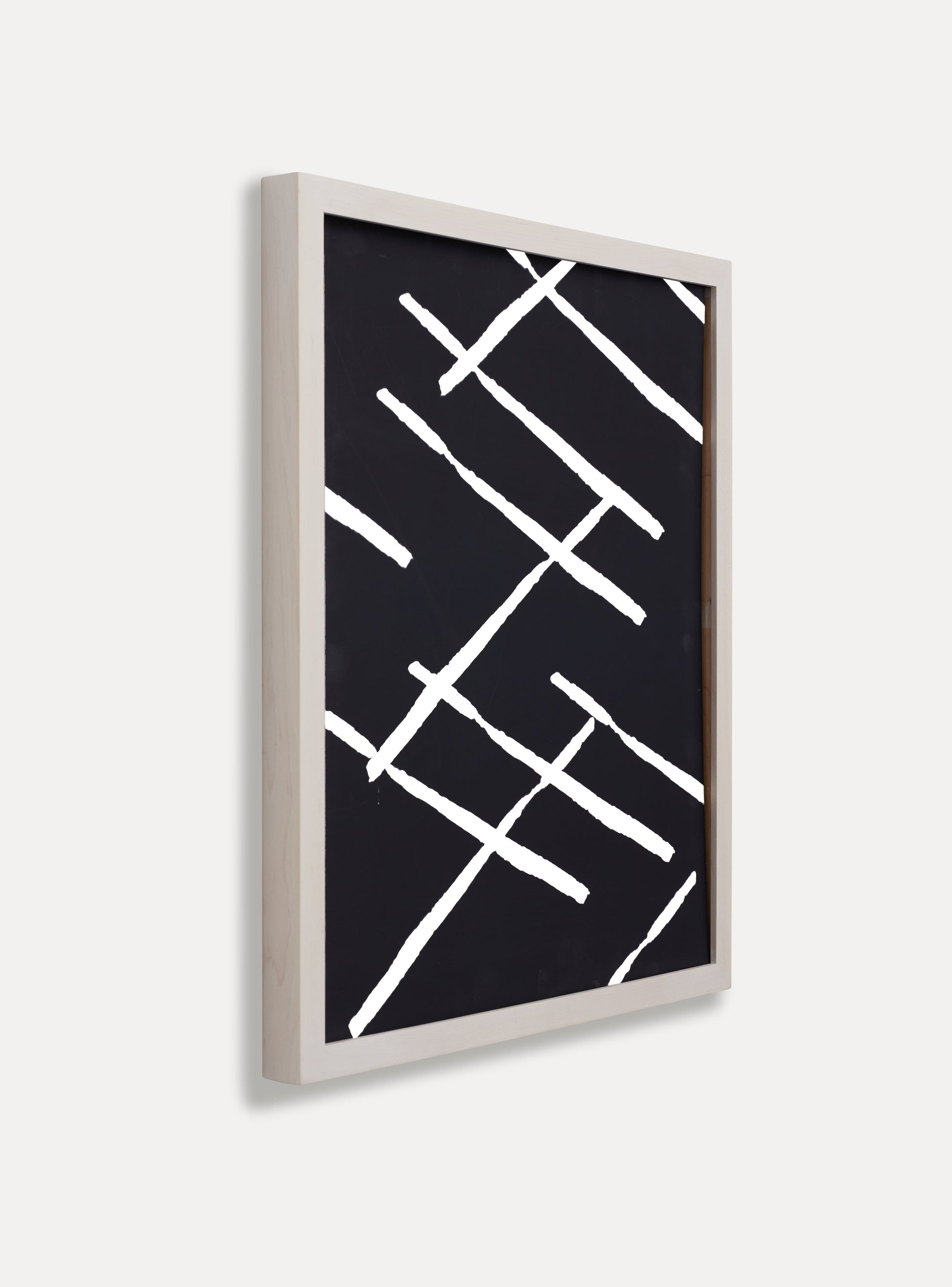 Side photo of a wooden picture frame on an off-white wall