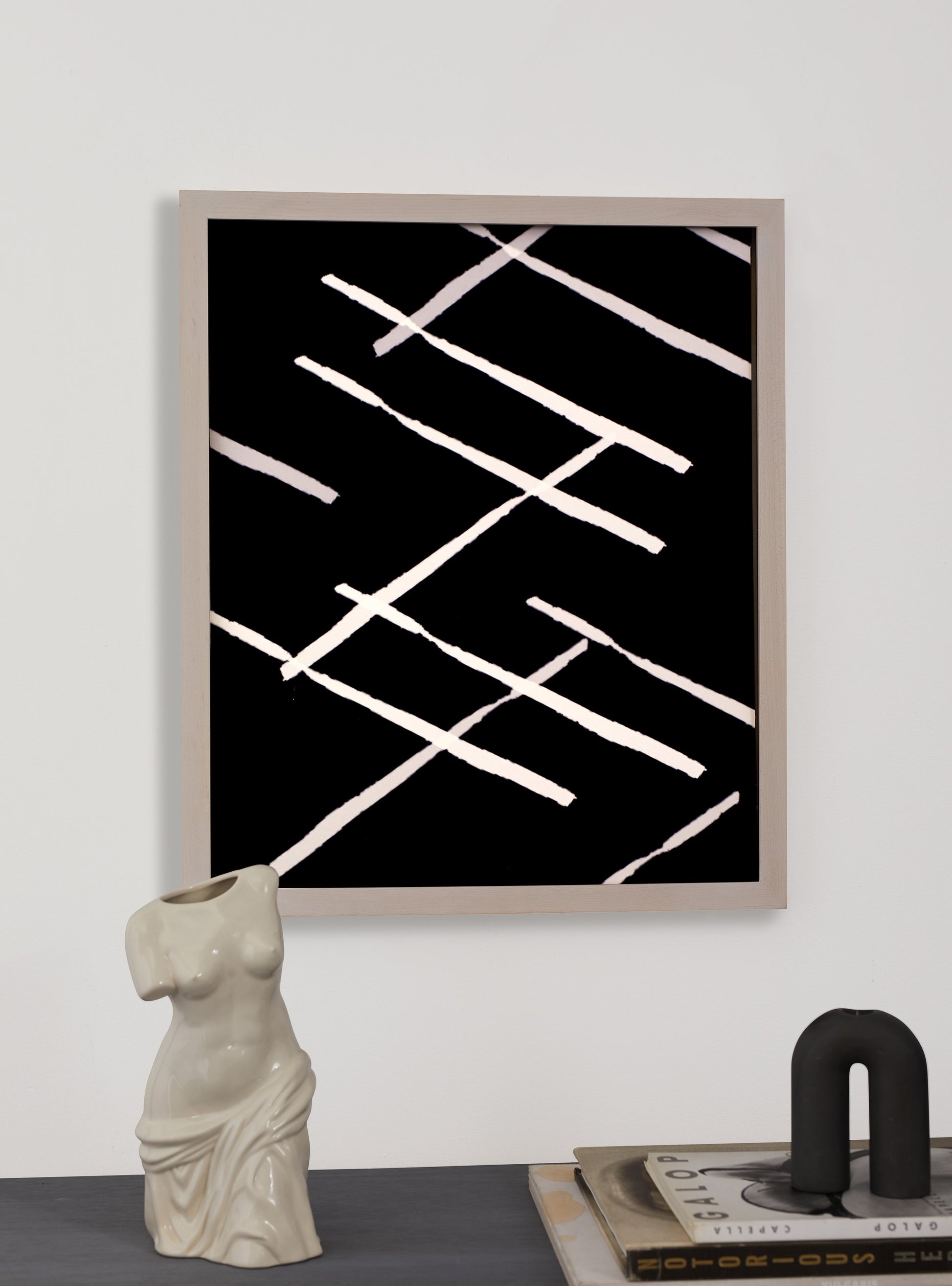 Photograph of a frame in a home with a table underneath showing various items