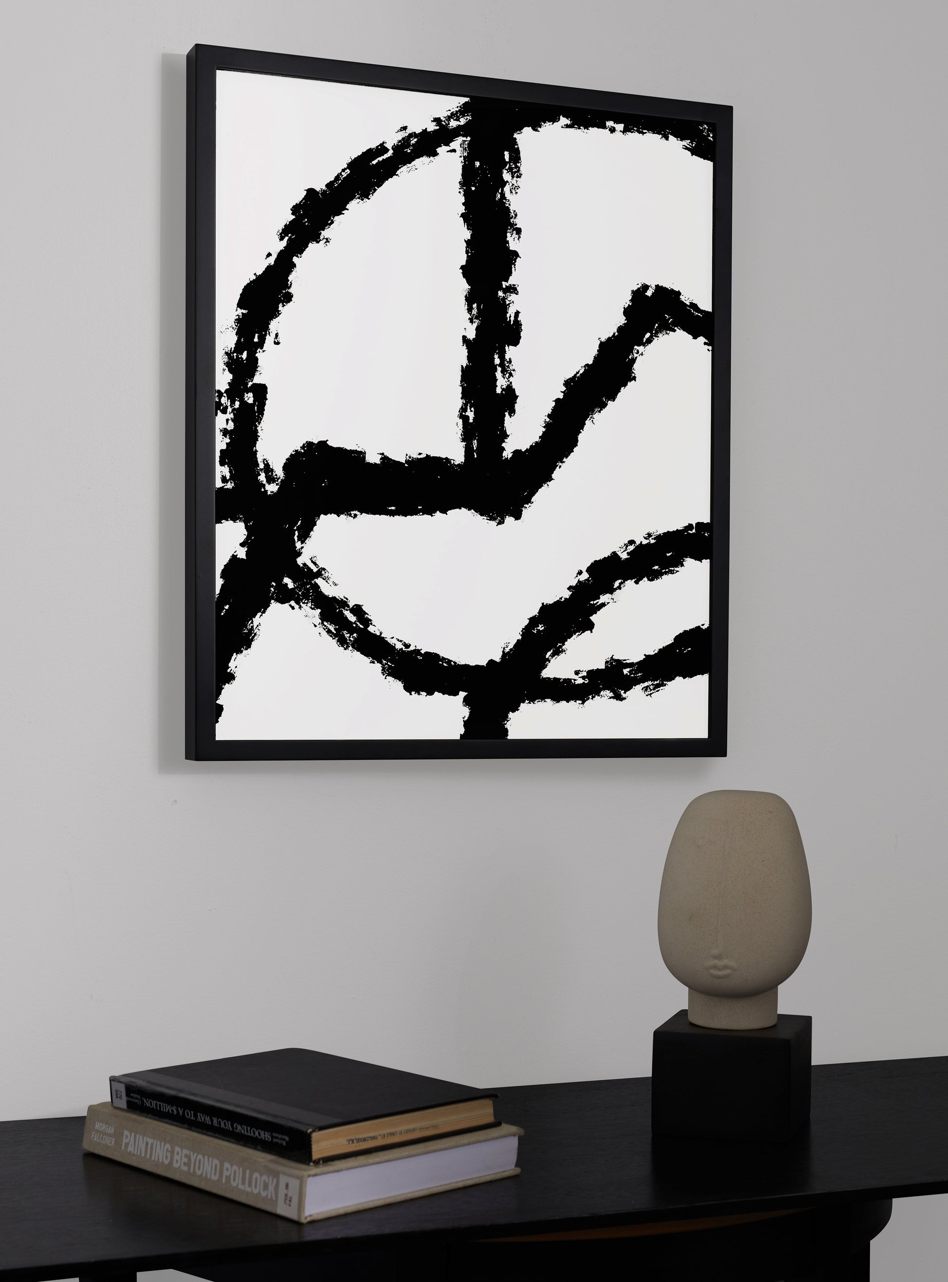 Photograph of a frame in a home with a table underneath showing various items