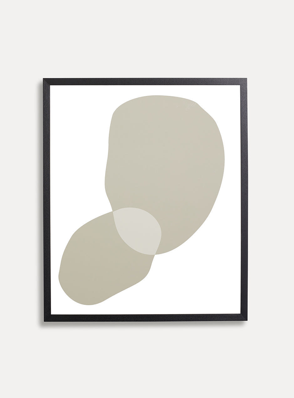 abstract tan print on white background in black frame on white wall