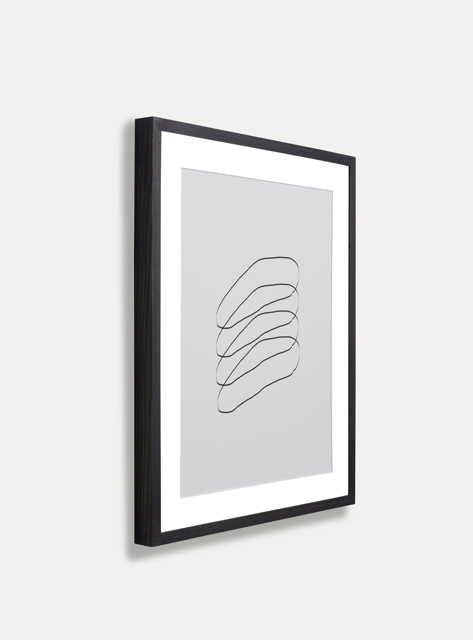 Side photo of a wooden picture frame on an off-white wall