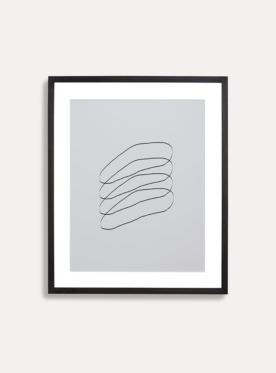 black and white abstract print in black frame on white wall