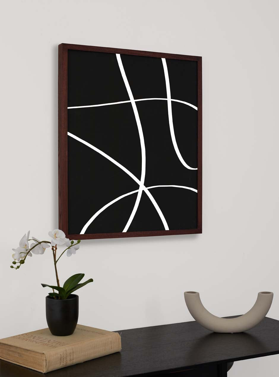 dark stained thin wooden frame holding abstract painting hung above table with various small objexts