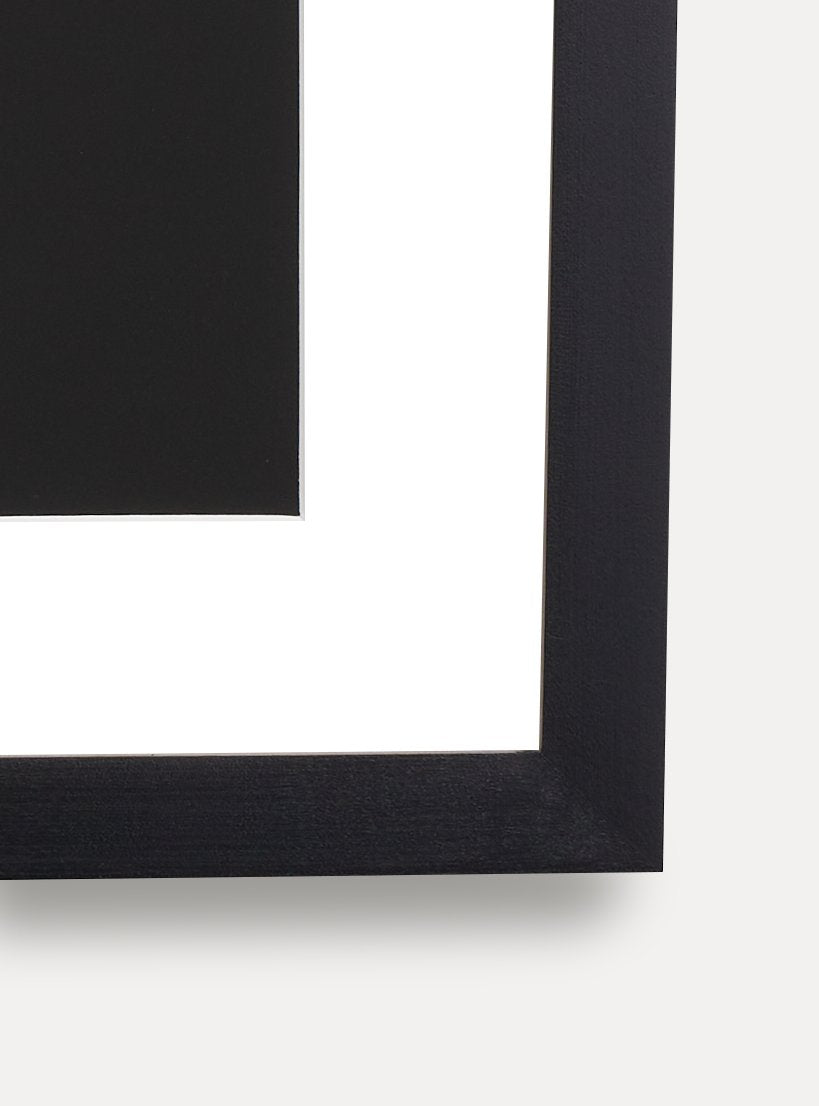 Up close detail photo of wooden frame showing wood grainblack solid maple frame with white matboard and black and white abstract art resembling a pound sign multiple times