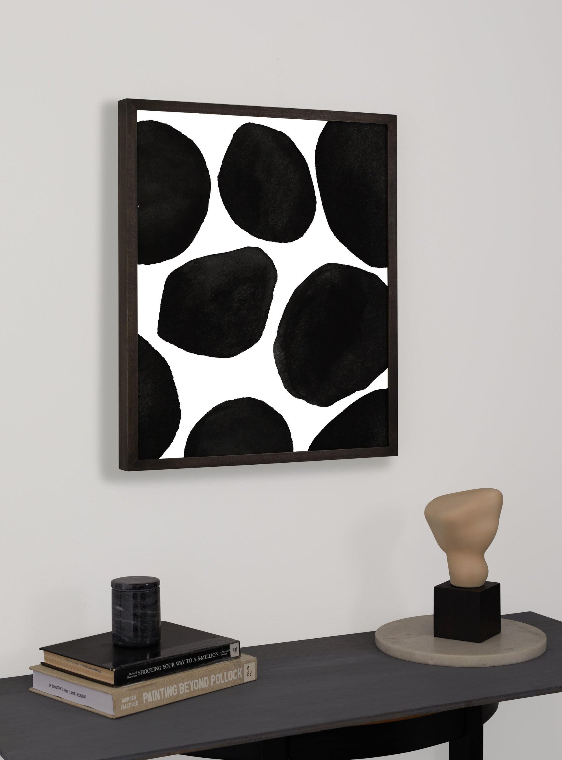 Photograph of a frame in a home with a table underneath showing various items